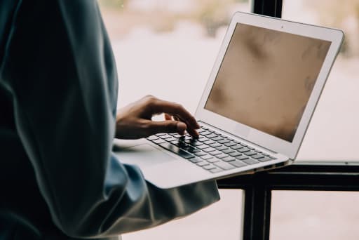 osoba pisząca na laptopie